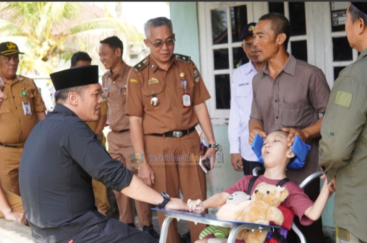 Bupati Pesisir Barat Serahkan Kursi Roda Khusus dan Paket Sembako Kepada Alief Gustian